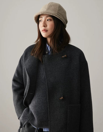 Woman wearing an oatmeal greige felt cloche hat with a minimalist dark autumn coat