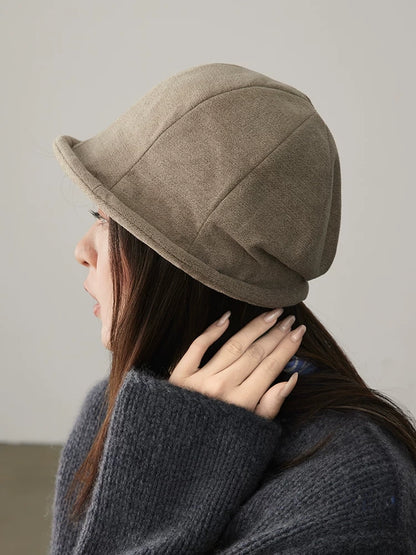 Side view of an oatmeal greige rolled brim cloche hat styled with a charcoal knit sweater