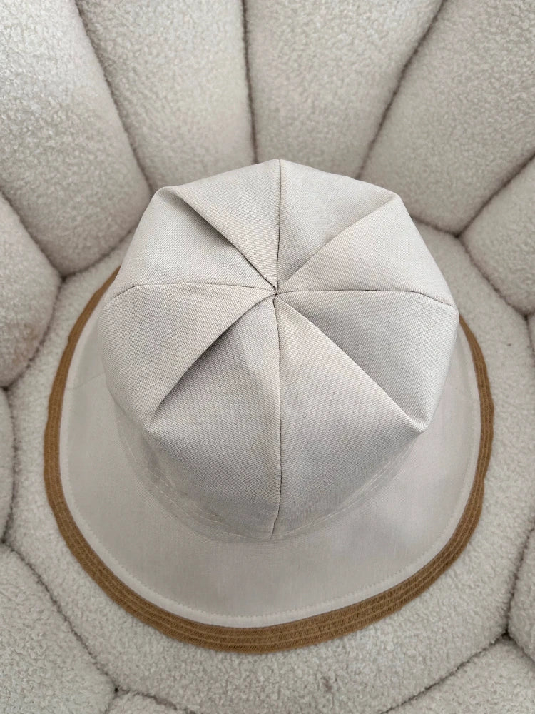 top view of off-white foldable wide brim sun hat with structured fabric crown