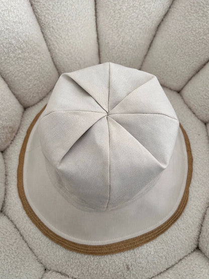 top view of off-white foldable wide brim sun hat with structured fabric crown