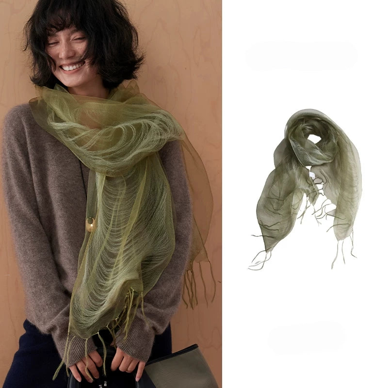 Woman wearing an olive green sheer mulberry silk fringe scarf with a brown sweater