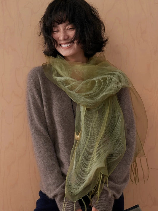 Olive green mulberry silk scarf wrapped loosely around the neck with fringed ends