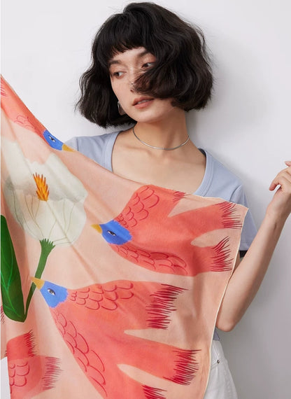 Pink floral bird silk square scarf shown on model with artistic spring pattern