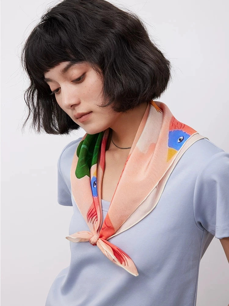 Woman wearing pink bird and floral silk square scarf as elegant neck scarf