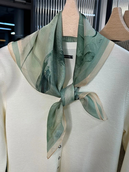 Green floral silk square scarf styled as elegant neck scarf on mannequin, plant-dyed mulberry silk