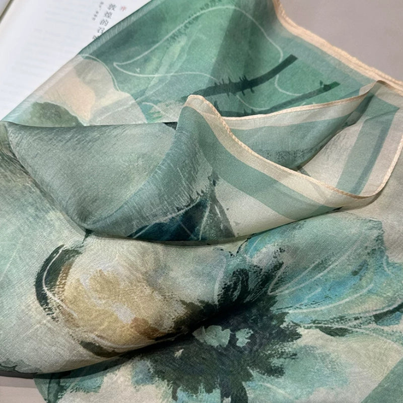 Detailed view of silk scarf square with green flower print, smooth mulberry silk fabric texture