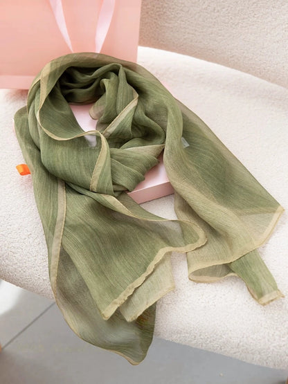 Light green gambiered mulberry silk long scarf styled in a soft layered drape