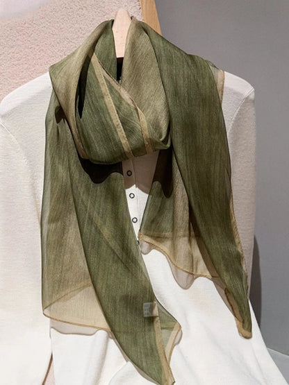 Light green plant-dyed long silk scarf styled over a white outfit for elegant layering