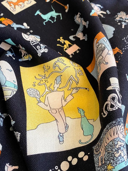 Close-up of whimsical multicolor illustrations on a black silk wool blend scarf