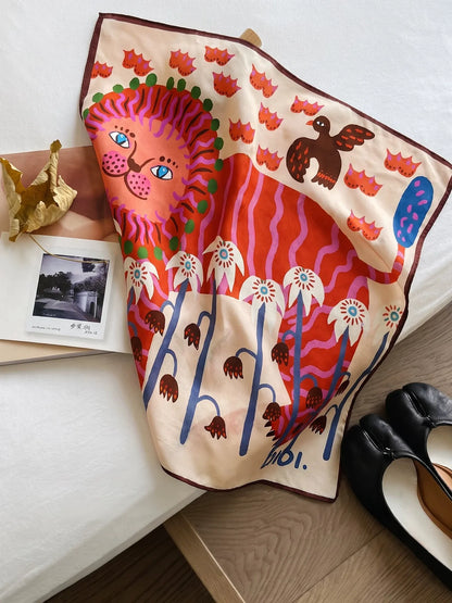 Cream mulberry silk square scarf with a coral lion and whimsical botanical print displayed on a chair