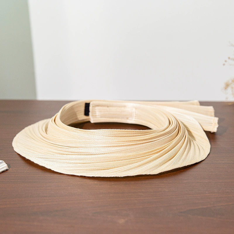 Pleated Buntal straw open top sun hat with extendable brim and natural woven texture.