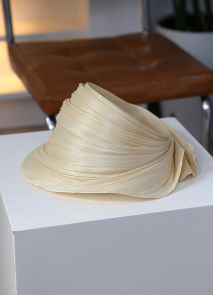 Natural Buntal straw open top sun hat with sculptural pleated brim for summer resort wear.