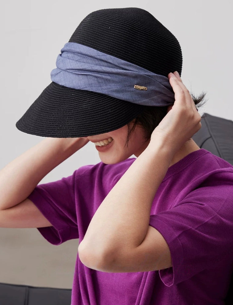 Foldable black sun visor hat with pleated ribbon detail for travel and summer wear
