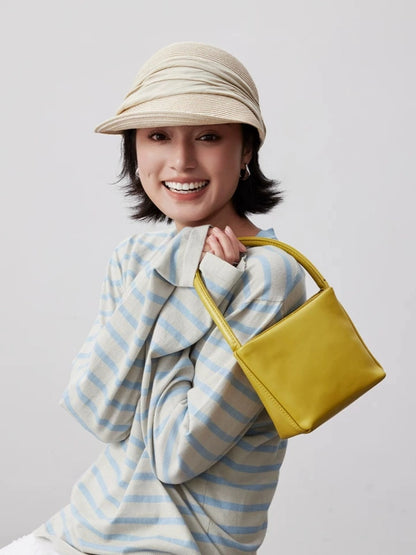 Ivory sun visor hat with pleated ribbon detail styled with a striped top and yellow bag
