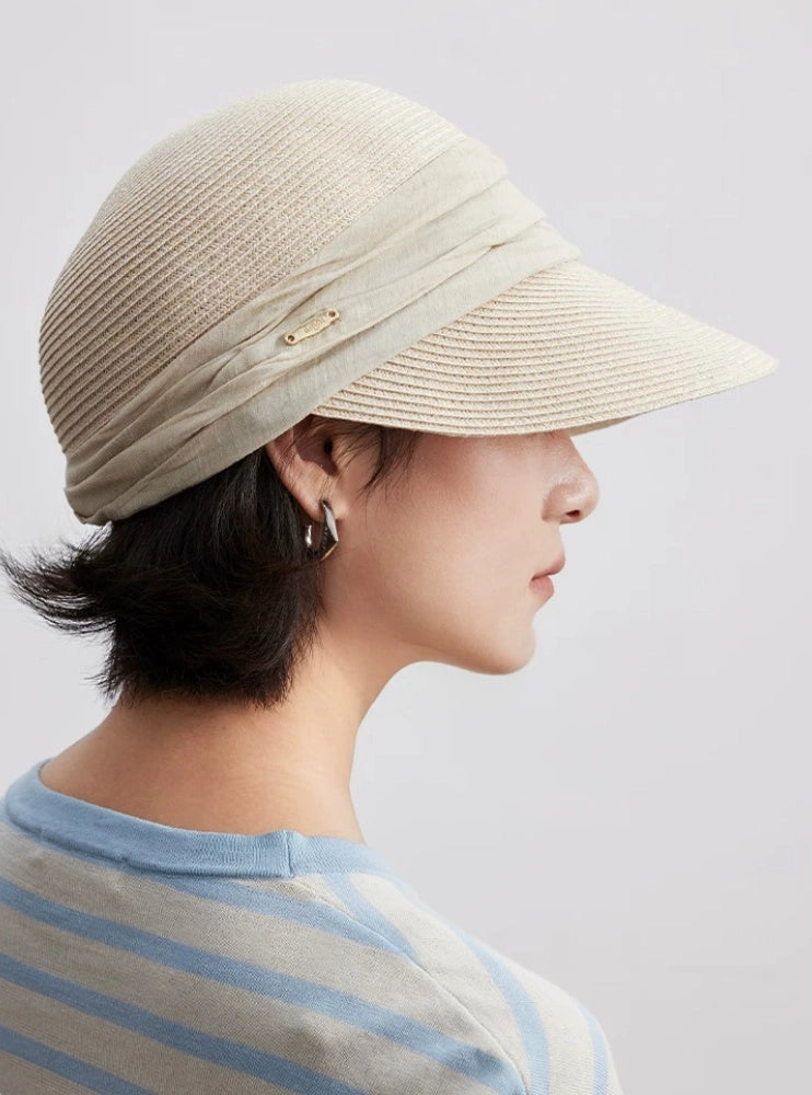 Ivory pleated ribbon sun visor hat shown from the back with adjustable summer fit
