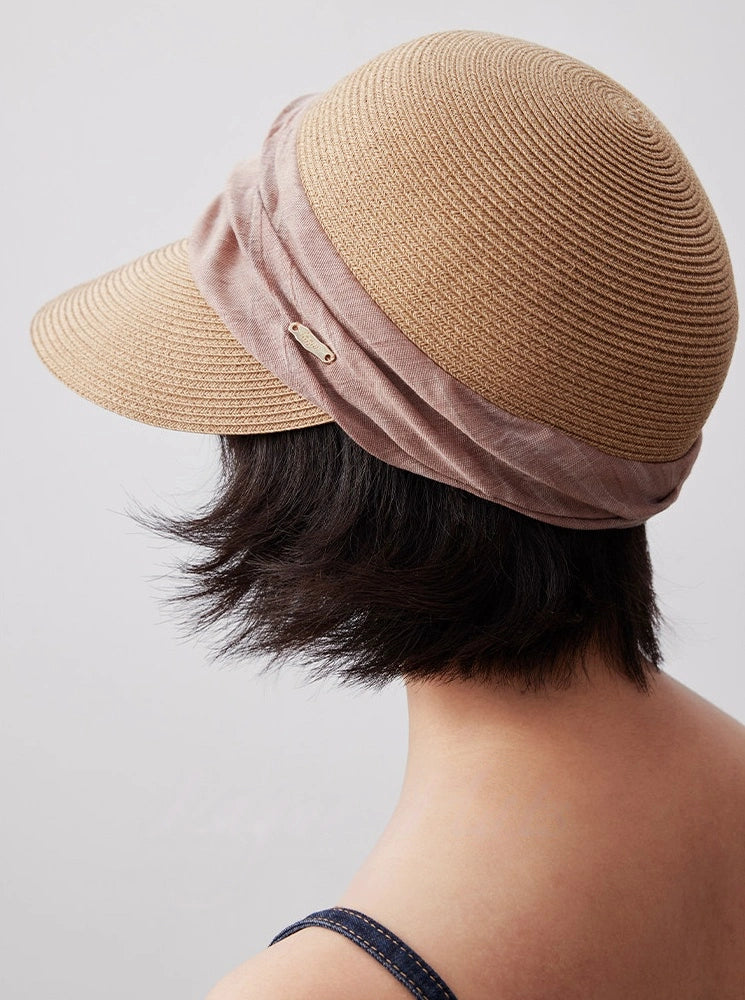 Natural beige sun visor hat shown from the back with dusty rose ribbon detail