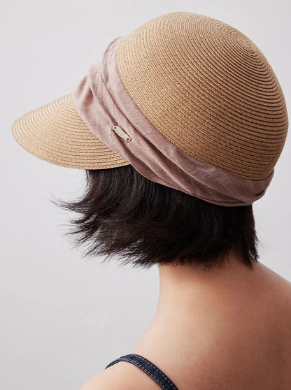 Natural beige sun visor hat shown from the back with dusty rose ribbon detail