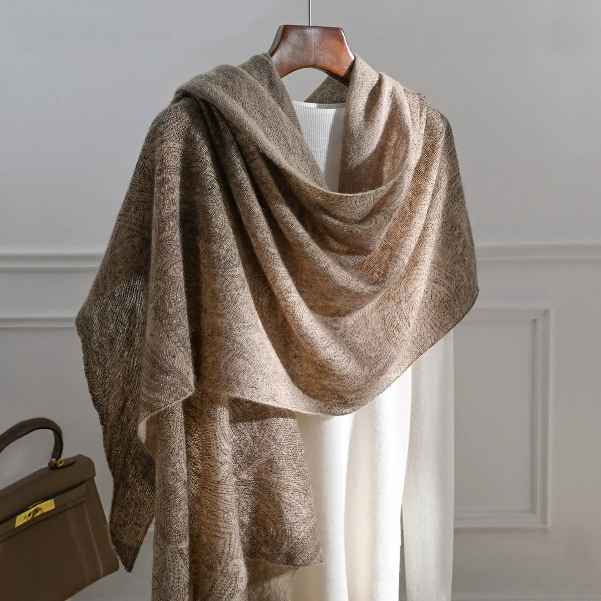 Plum brown cashmere scarf with a tonal paisley pattern draped over a white top.