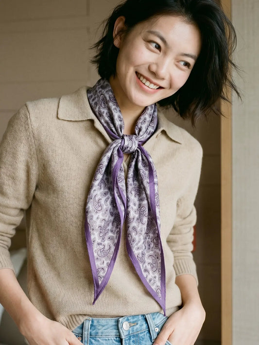 Purple paisley diamond scarf tied loosely at the neck with a casual knit outfit