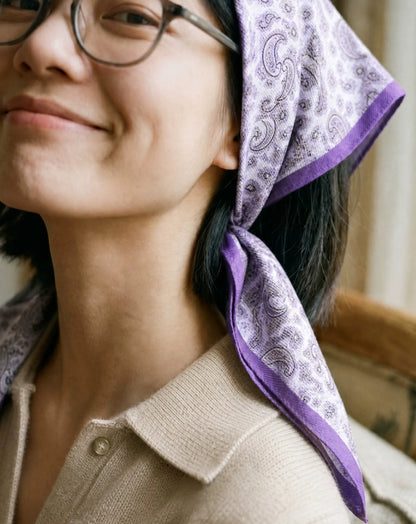 Woman styling a purple paisley silk wool scarf as a vintage headscarf