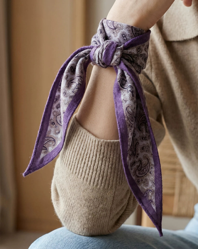 Purple paisley silk wool scarf tied around the wrist as a soft accessory