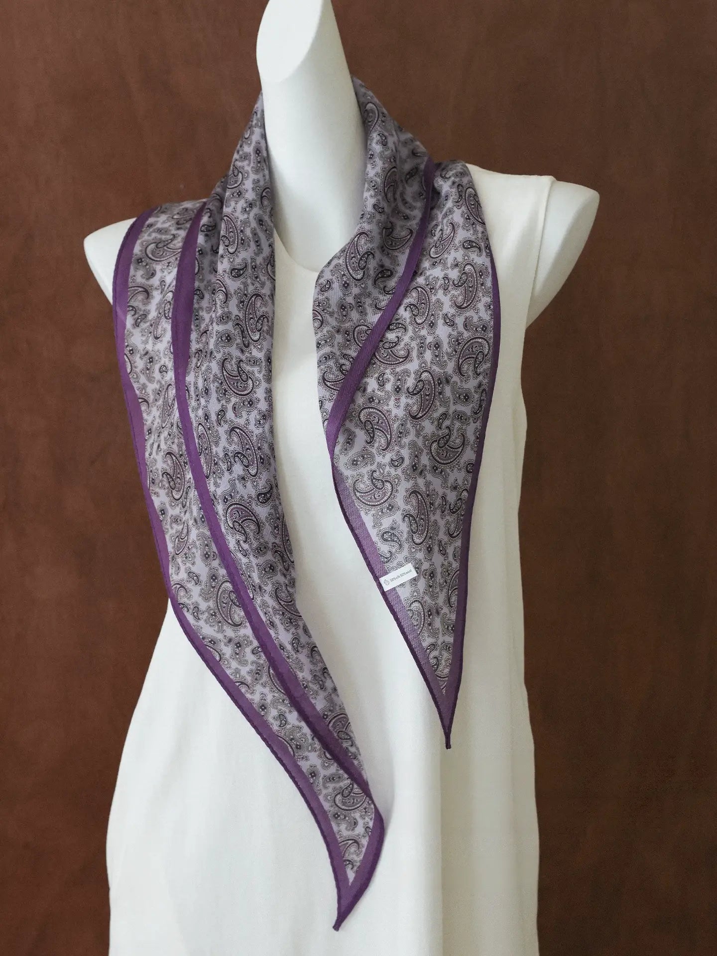 Purple paisley diamond scarf draped over a white dress form to show its shape