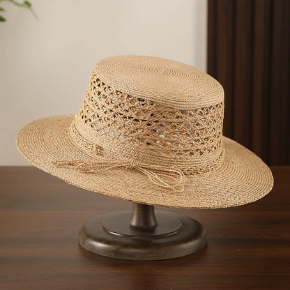 Beige raffia straw boater hat with hollow open weave crown and wide brim.