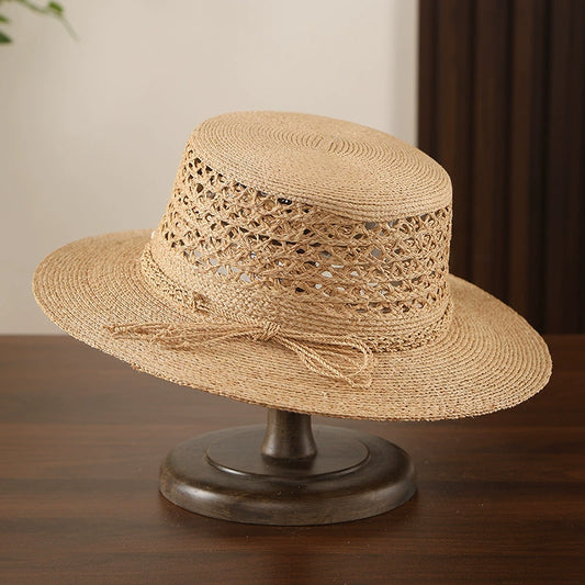 Beige raffia straw boater hat with hollow open weave crown and wide brim.