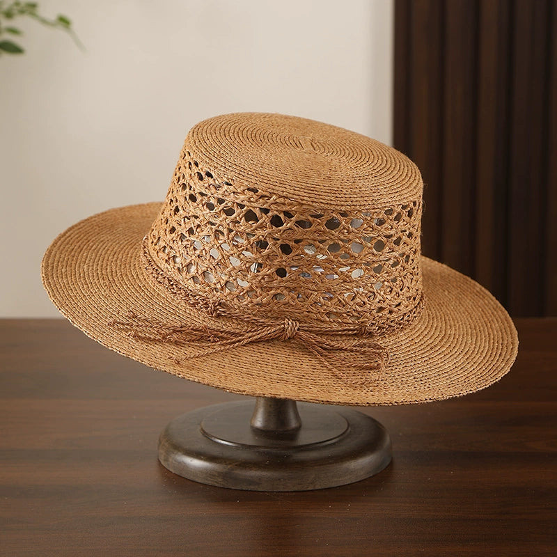 Antique bronze raffia straw boater hat with open weave crown and bow tie detail.