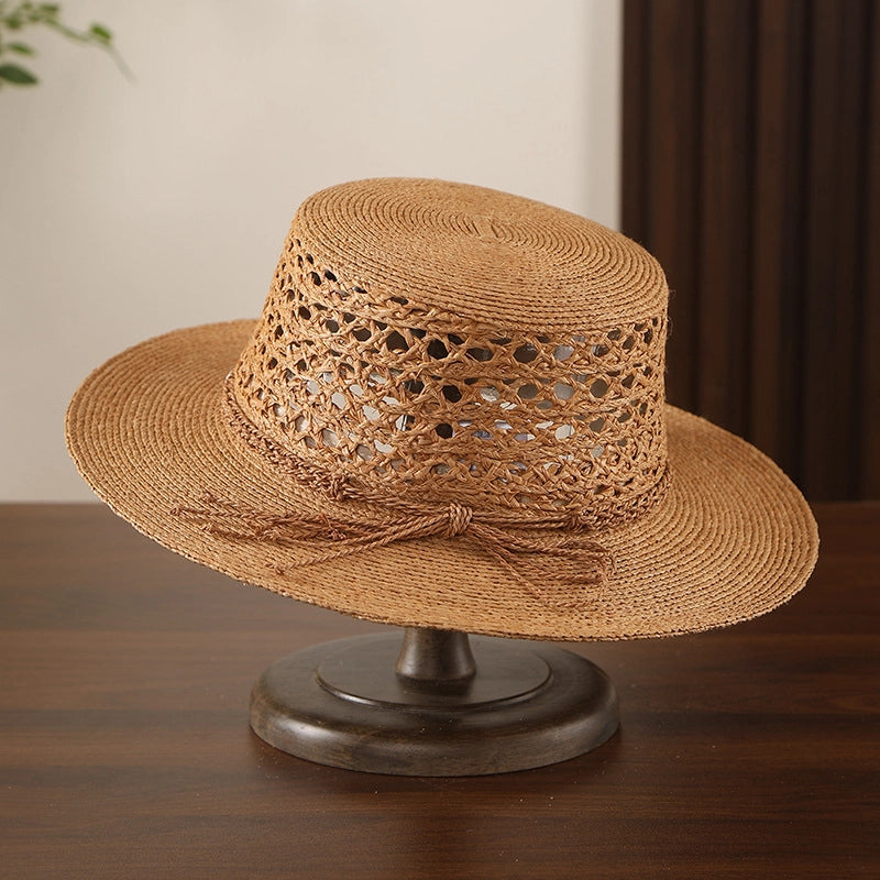 Bronze boater style raffia sun hat with hollow woven crown and resort wear look.