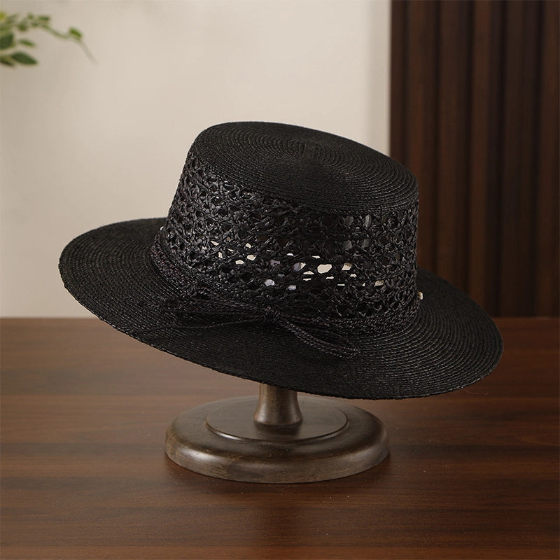 Black raffia straw boater hat with hollow open weave crown and wide brim.