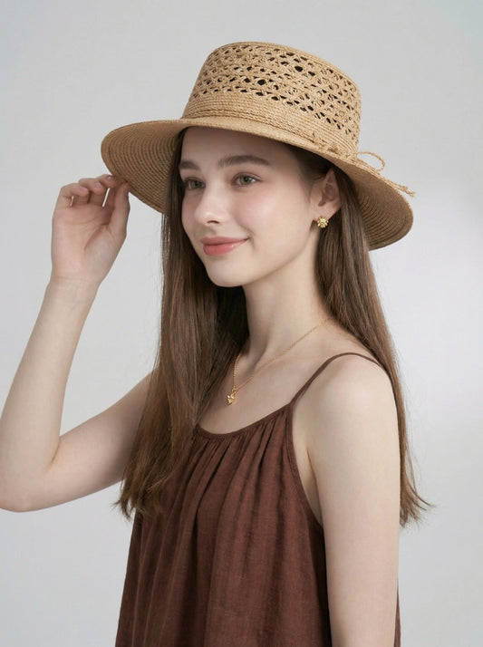 Model wearing beige raffia straw boater hat with wide brim and open weave crown.