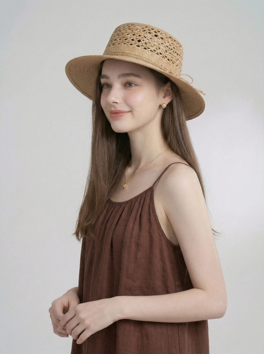Beige raffia straw boater hat styled on model for summer resort wear.