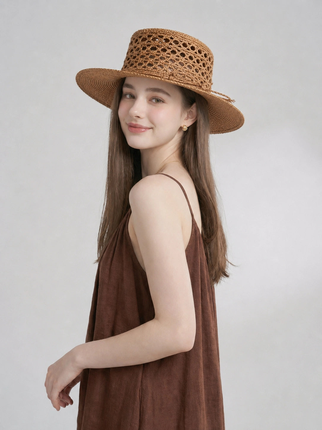 Side view of model wearing bronze raffia straw boater hat for summer styling.