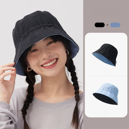 Woman wearing a black navy reversible cotton linen bucket hat with the light blue reverse side shown
