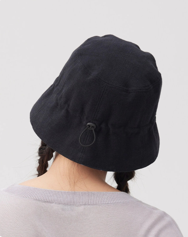 Back view of a black navy cotton linen bucket hat showing the adjustable drawstring detail