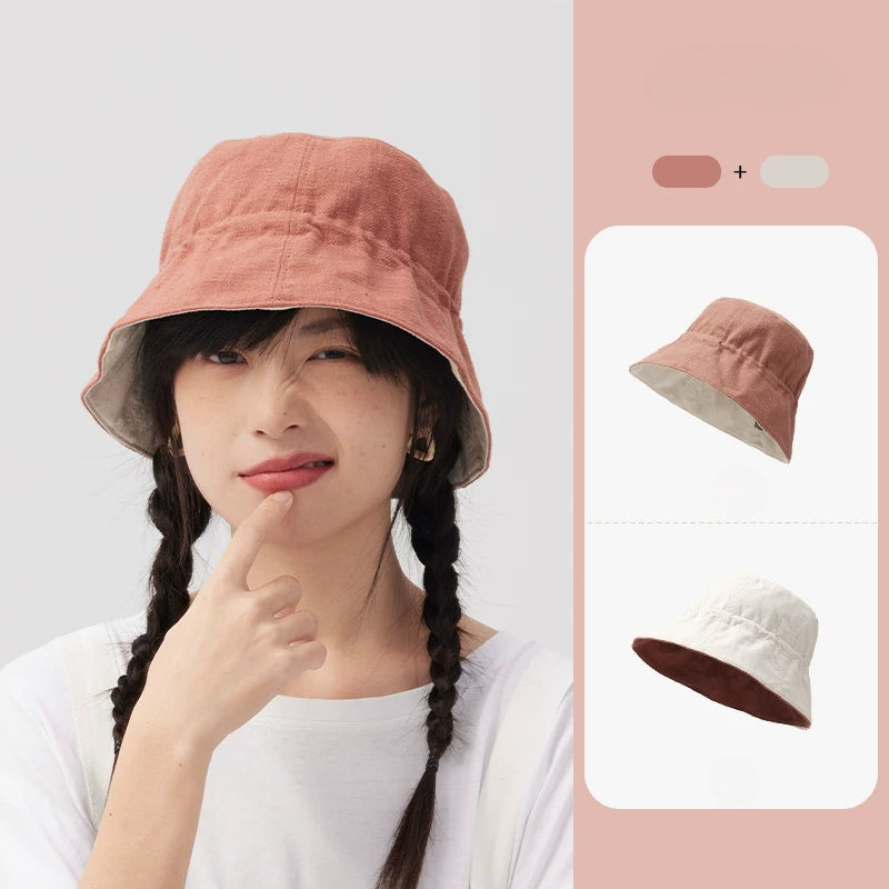 Woman wearing an orange pink reversible cotton linen bucket hat with the light neutral reverse side shown