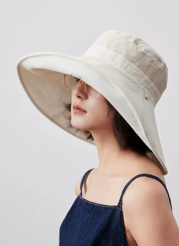Model wearing an ivory wide brim cotton linen sun hat for summer sun protection