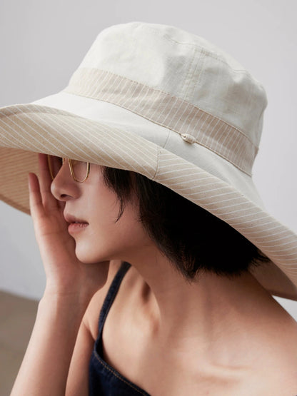 Close-up of ivory reversible cotton linen sun hat with wide brim and breathable texture
