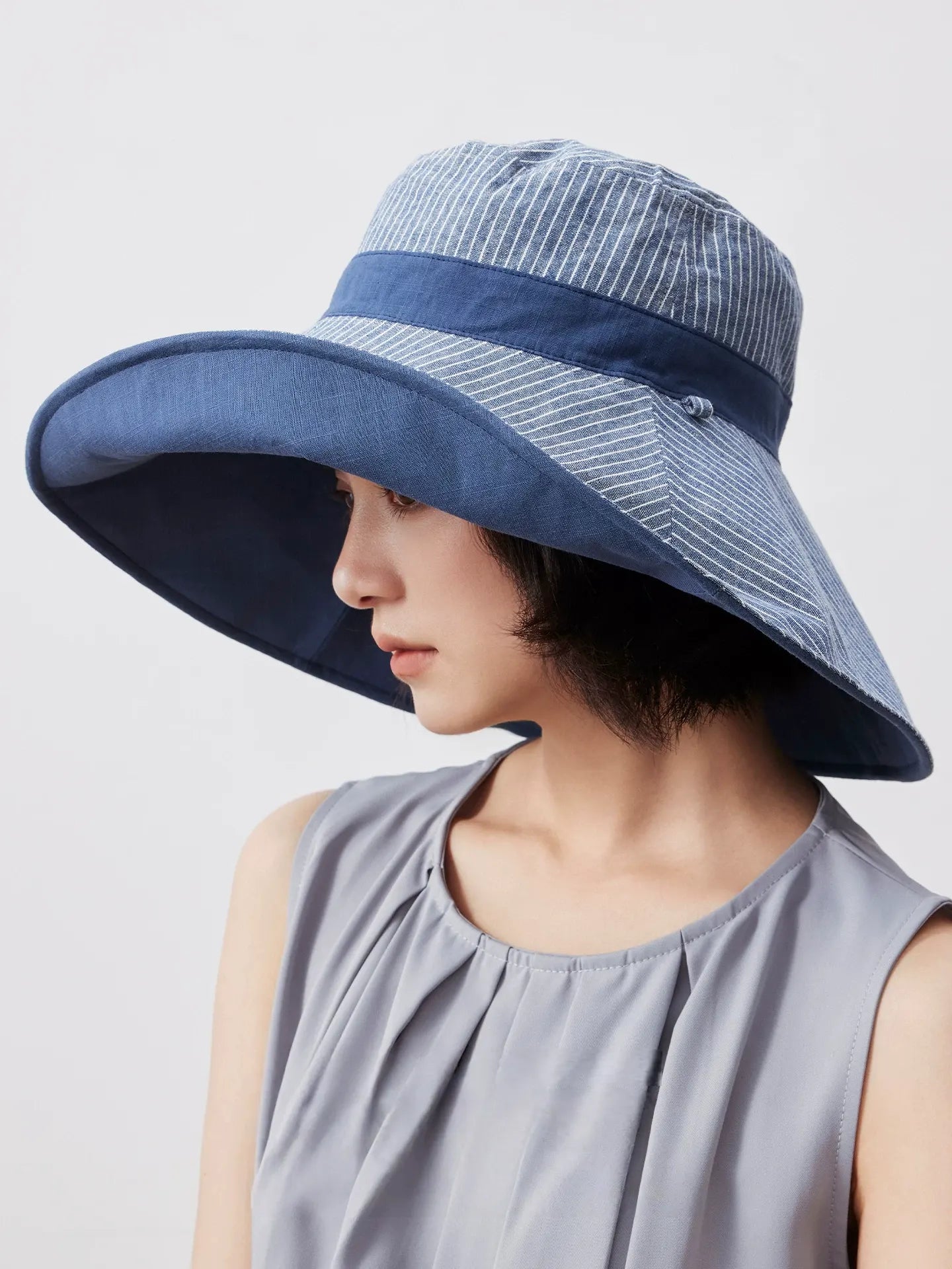 Smoky blue reversible sun hat styled with a casual sleeveless summer top