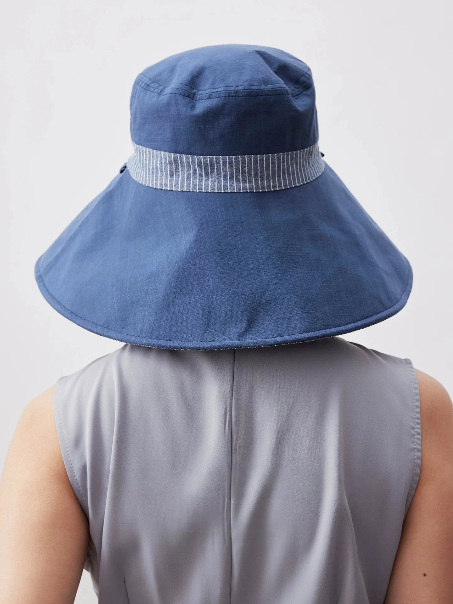 Back view of smoky blue foldable cotton linen sun hat with wide brim