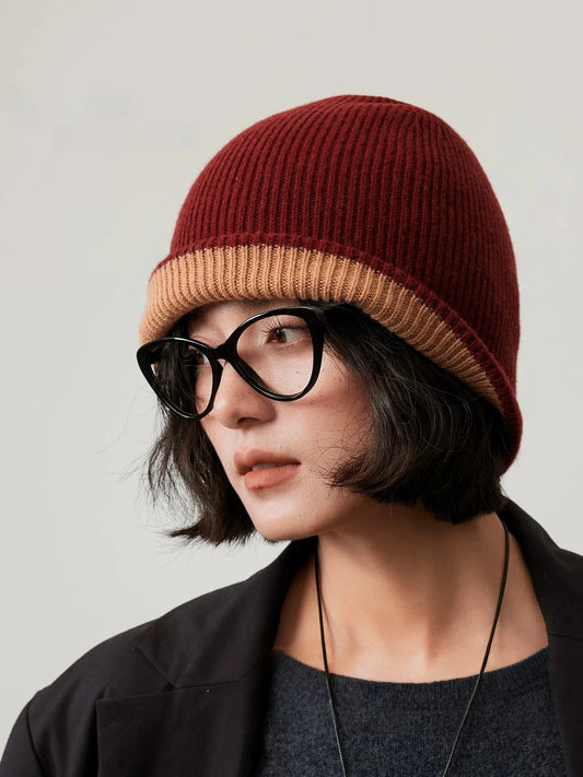 Three-quarter view of a rust brown wool beanie with a camel cuff, styled with a black blazer.