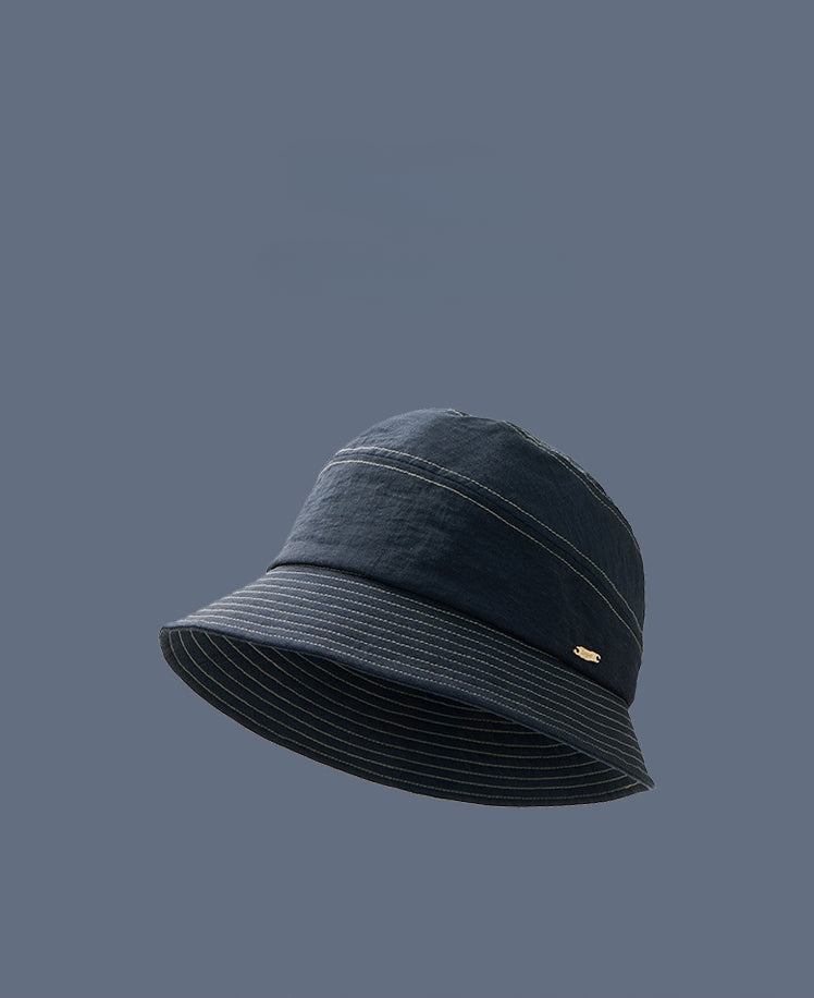 Denim blue short brim bucket hat side profile on model, foldable travel bucket hat for women