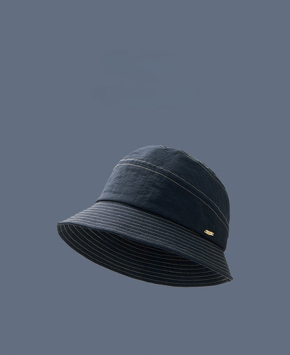 Denim blue short brim bucket hat side profile on model, foldable travel bucket hat for women