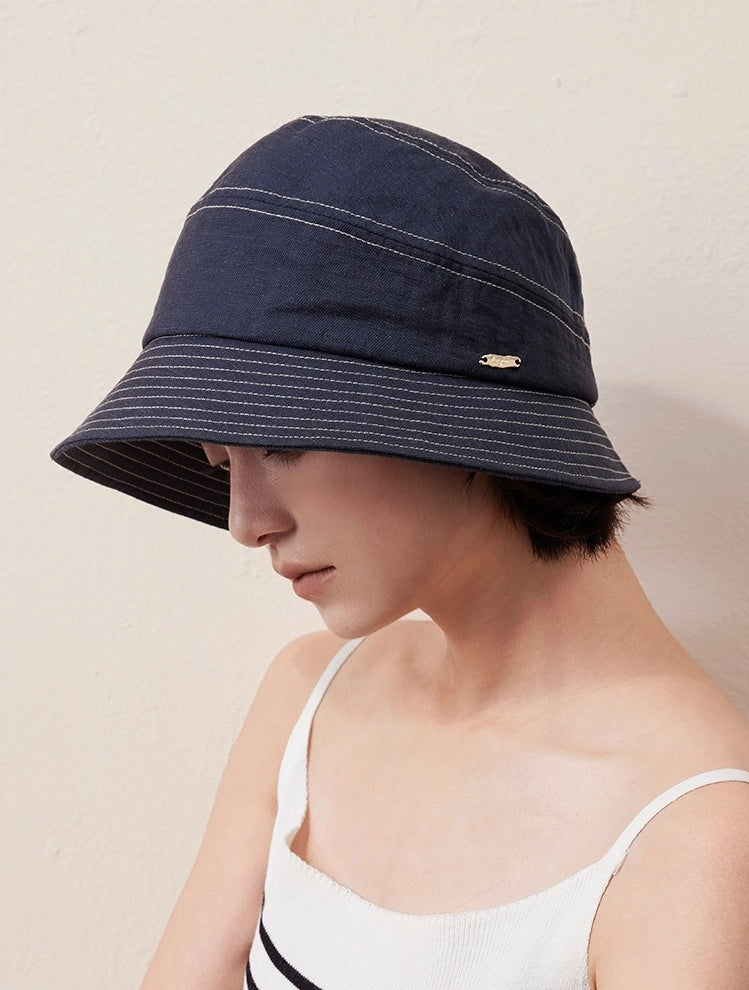 Denim blue short brim bucket hat front angle on smiling model, elegant women's sun hat