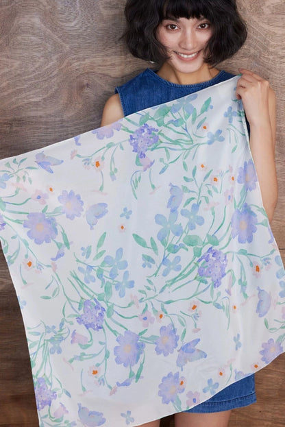Large silk square scarf with elegant watercolor floral print held open for styling display