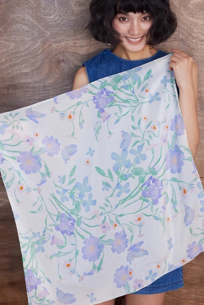 Elegant square silk scarf with watercolor floral design, flowing gracefully in a soft breeze.