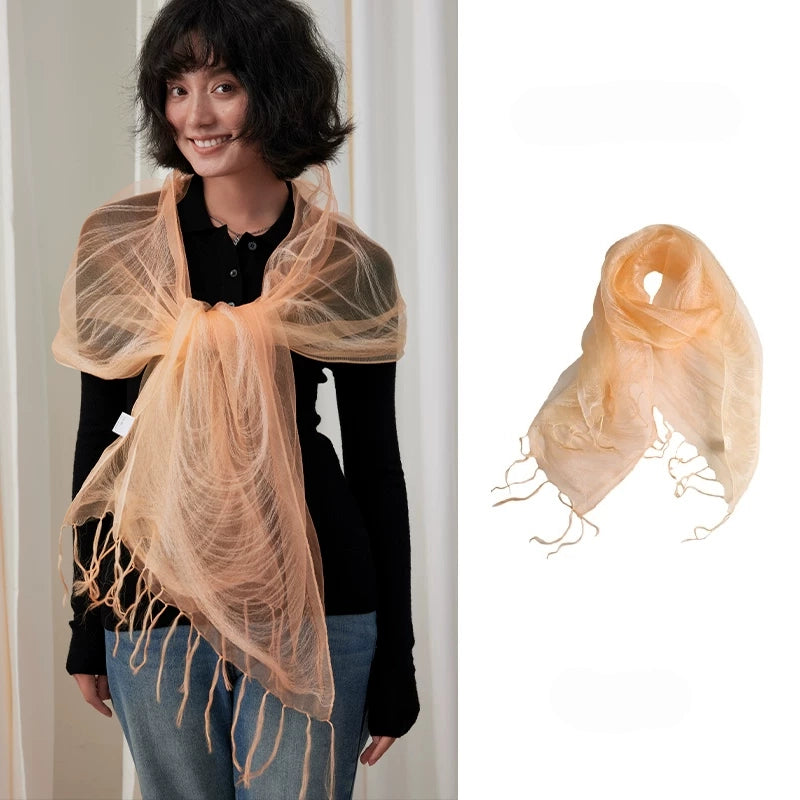 Woman wearing a sweet orange sheer mulberry silk fringe scarf over a black top
