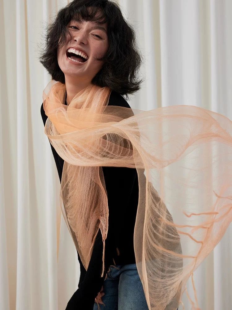 Sweet orange mulberry silk scarf flowing loosely around the neck and shoulders