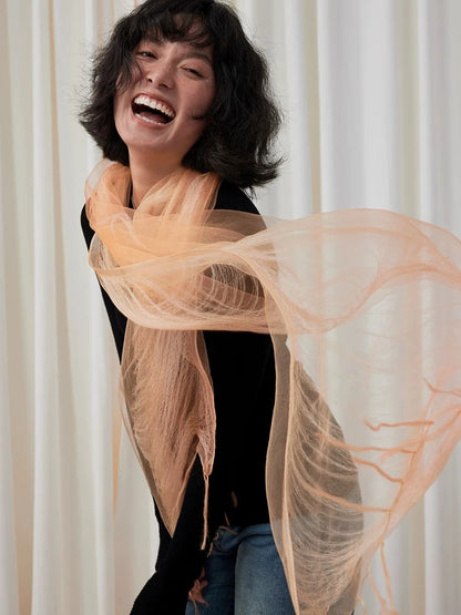 Sweet orange mulberry silk scarf flowing loosely around the neck and shoulders